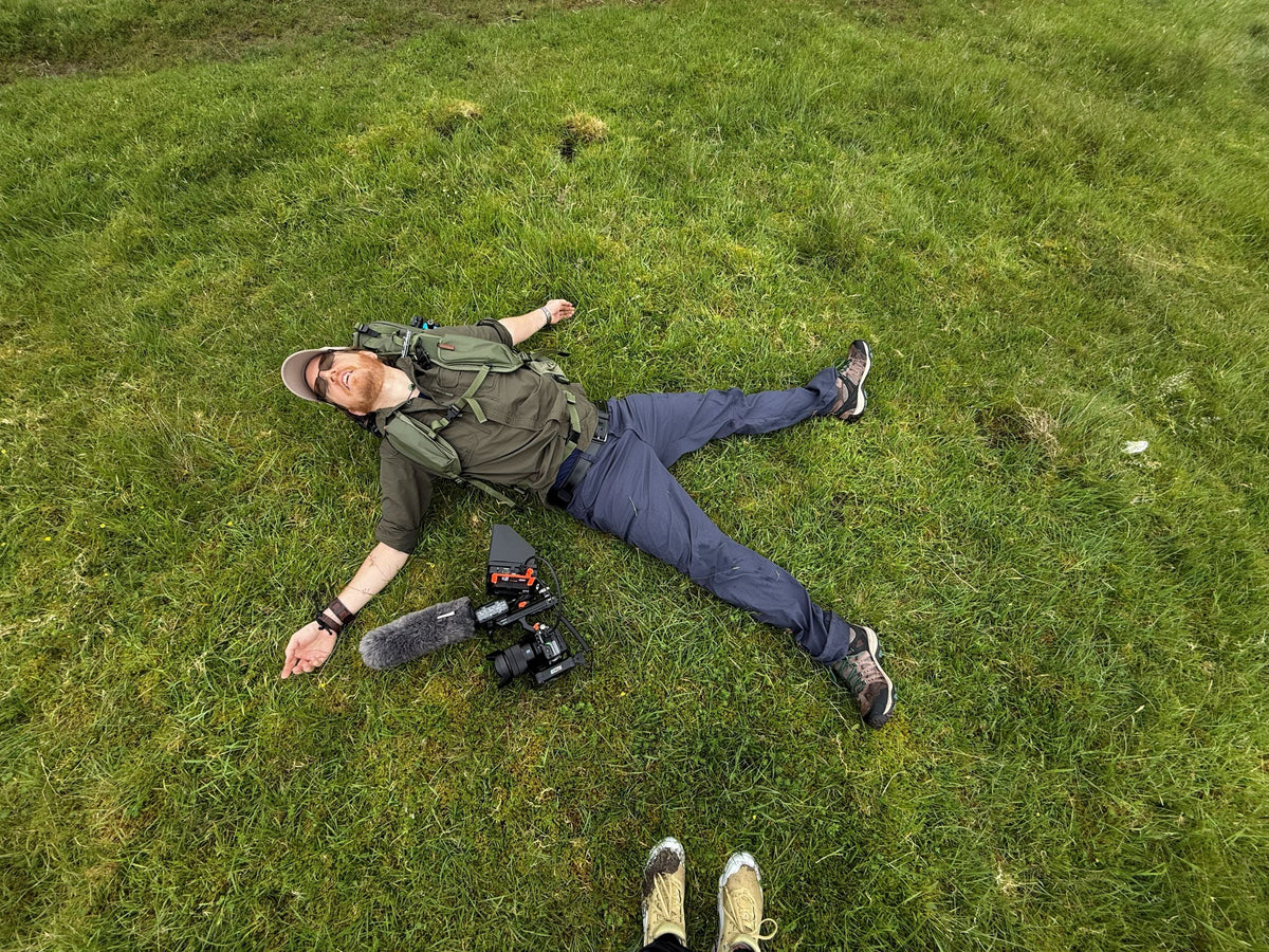 man laying on grass in starfish position